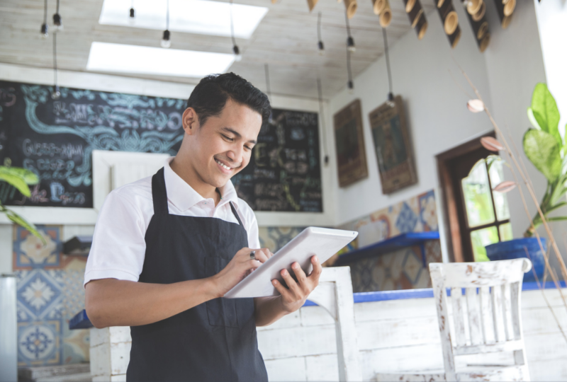 Male asian cafe owner with tablet (mobile POS)