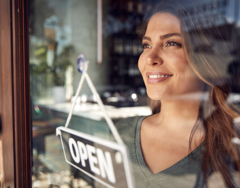 woman staring out front door of restaurant with open sign